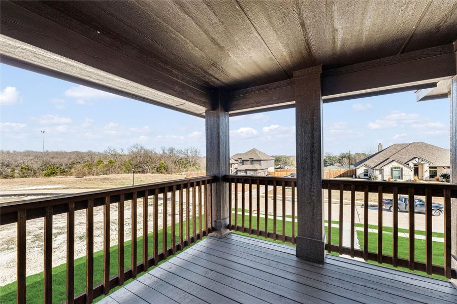 Covered wood deck with dark railings and open view of neighborhood and open land Covered wood deck with dark railings and open view of neighborhood and open land