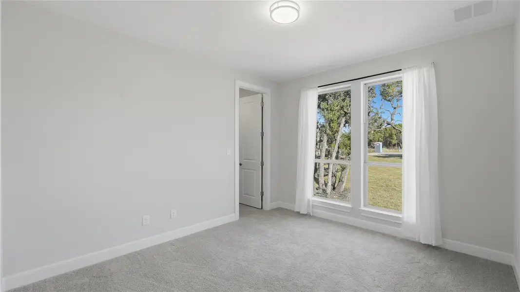 Empty room featuring light colored carpet and baseboards Empty room featuring light colored carpet and baseboards