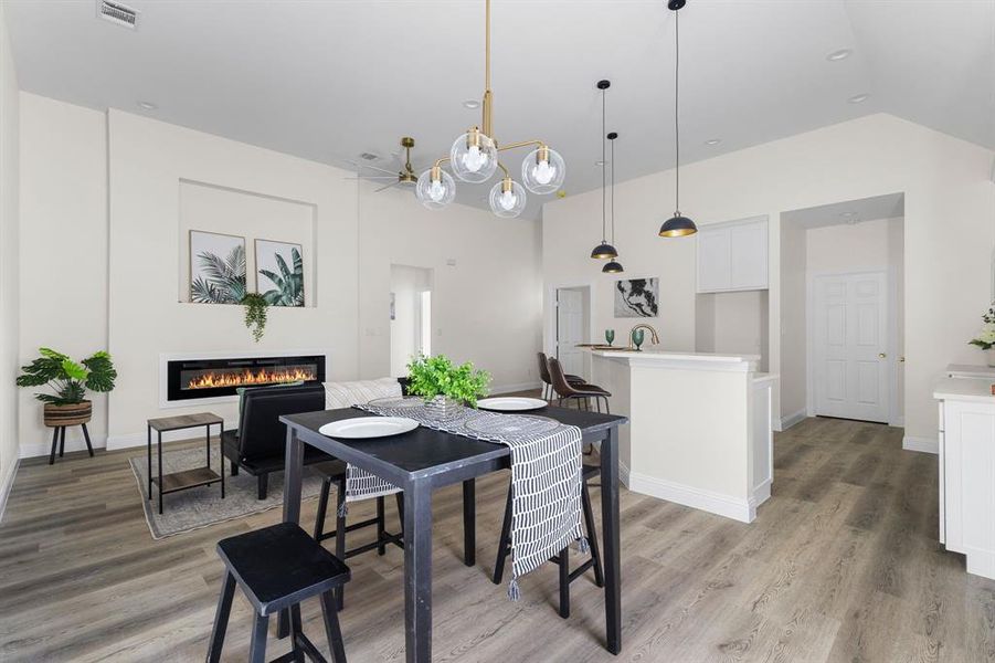 Dining space featuring vaulted ceiling and light wood-type flooring