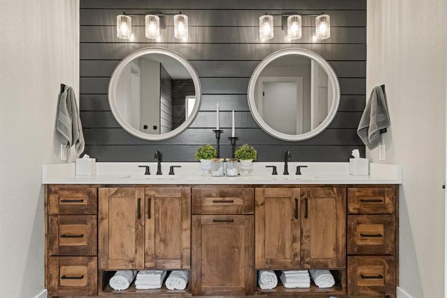 En suite  bathroom featuring double vanity with decorator touches through out.