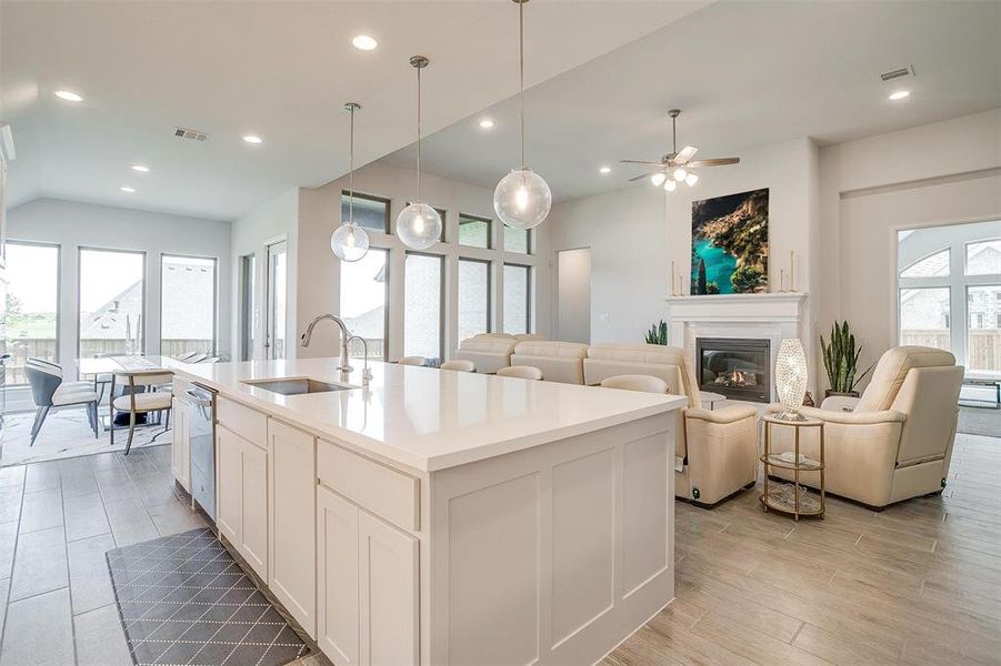 Kitchen with healthy amount of natural light, a glass covered fireplace, recessed lighting, light wood finished floors, and open floor plan Kitchen with healthy amount of natural light, a glass covered fireplace, recessed lighting, light wood finished floors, and open floor plan