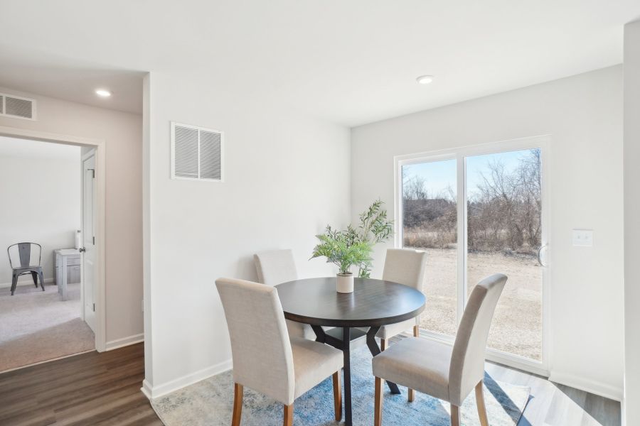 A dining room with a table and chairs.
