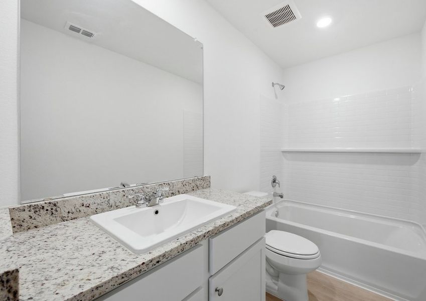 Secondary bathroom featuring a vanity with granite countertop and a tub/shower combination. Secondary bathroom featuring a vanity with granite countertop and a tub/shower combination.