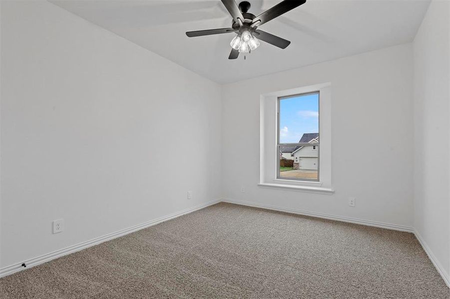 Carpeted empty room with ceiling fan