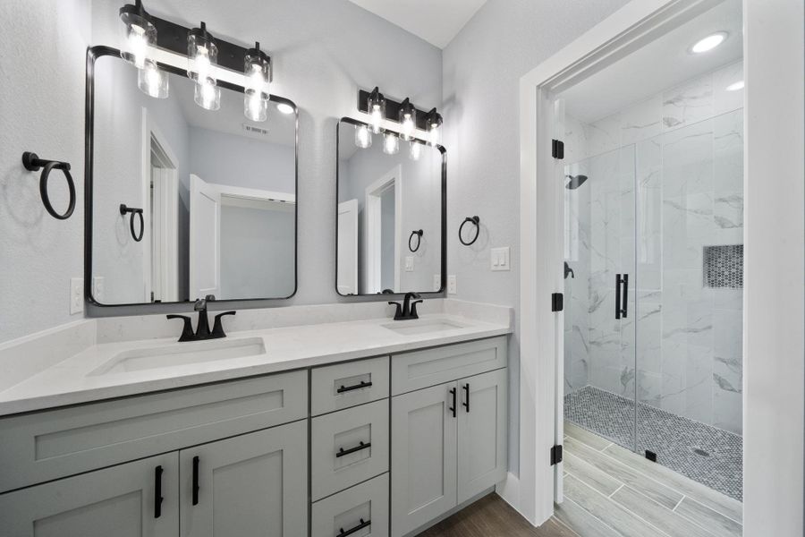 Dual vanity with light gray cabinetry and white countertops