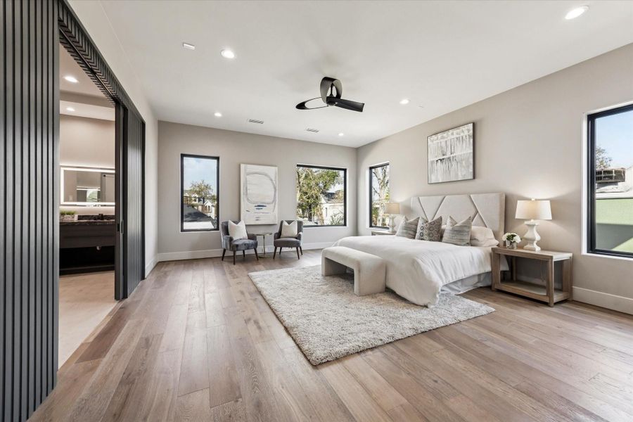 The large primary bedroom offers a spacious retreat designed for comfort and relaxation. An entertainment center is thoughtfully positioned at the foot of the bed, creating a perfect space to unwind and enjoy while maintaining a clean, functional layout.