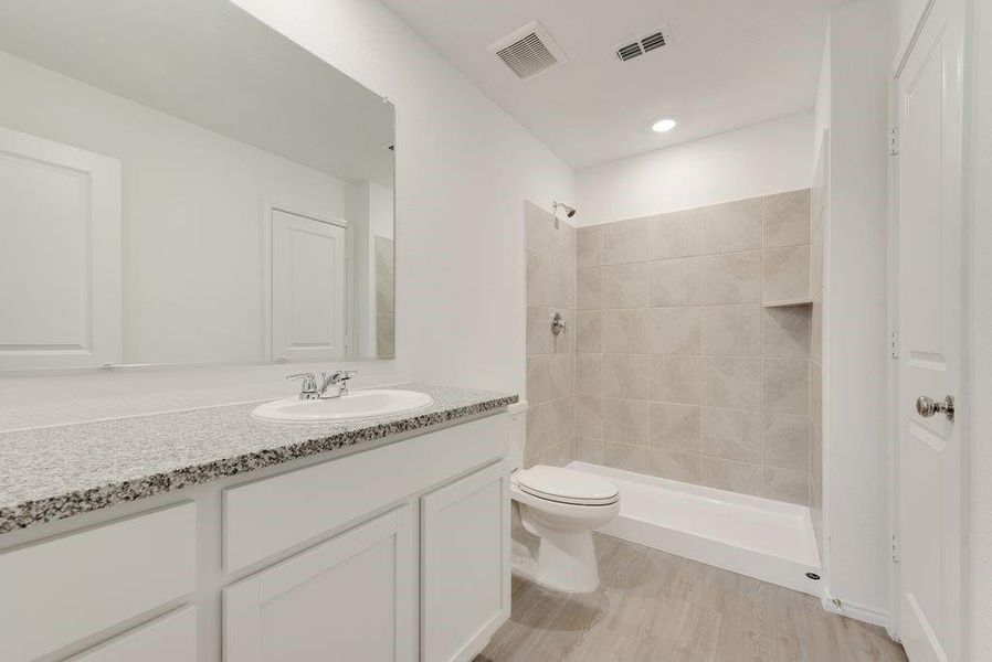 Full bath with visible vents, a shower stall, and toilet