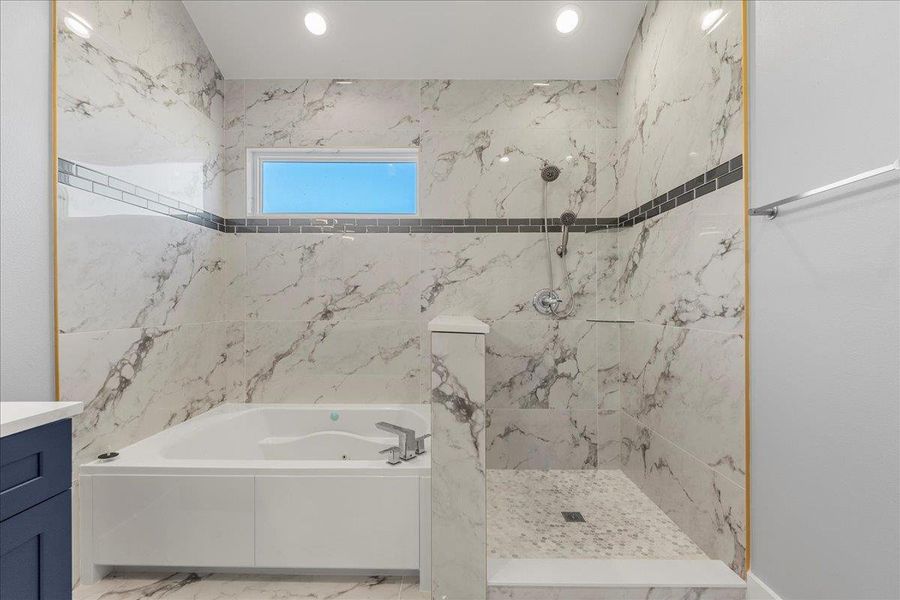 Bathroom featuring a garden tub, vanity, a marble finish shower, marble look tile flooring, and recessed lighting Bathroom featuring a garden tub, vanity, a marble finish shower, marble look tile flooring, and recessed lighting