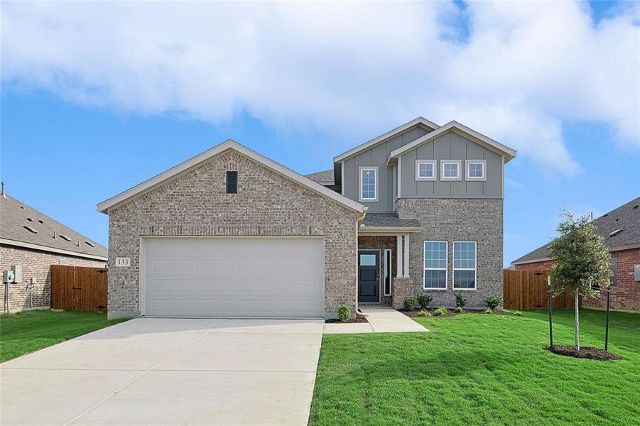 View of front of house featuring a garage and a front lawn