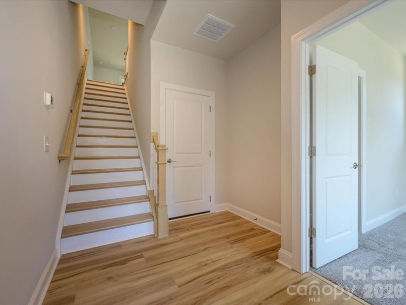 Foyer and oak box stairs with open rails