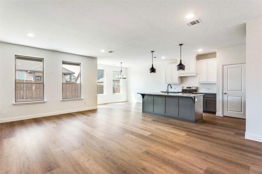 Kitchen with a sink, stainless steel stove, plenty of natural light, dark wood finished floors, and recessed lighting
