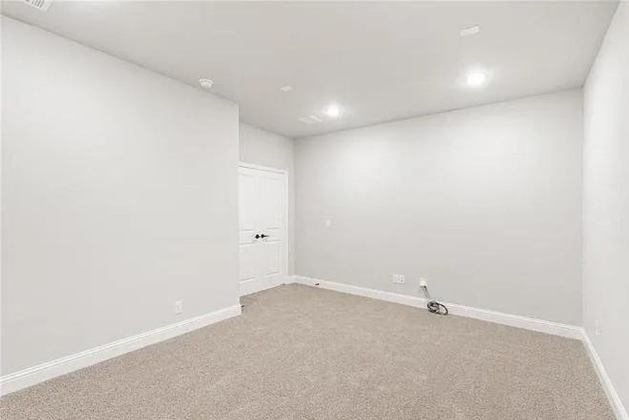 Empty room featuring light colored carpet, baseboards, and recessed lighting