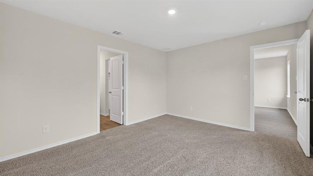 Expansive room featuring plush gray carpeting, neutral wall finishes, and white trim