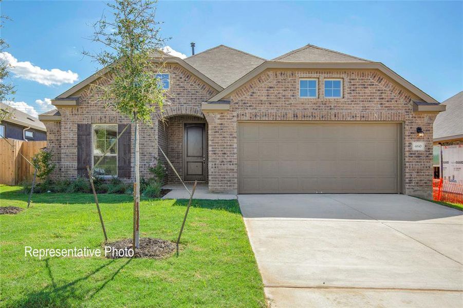 View of front of property featuring a garage and a front yard