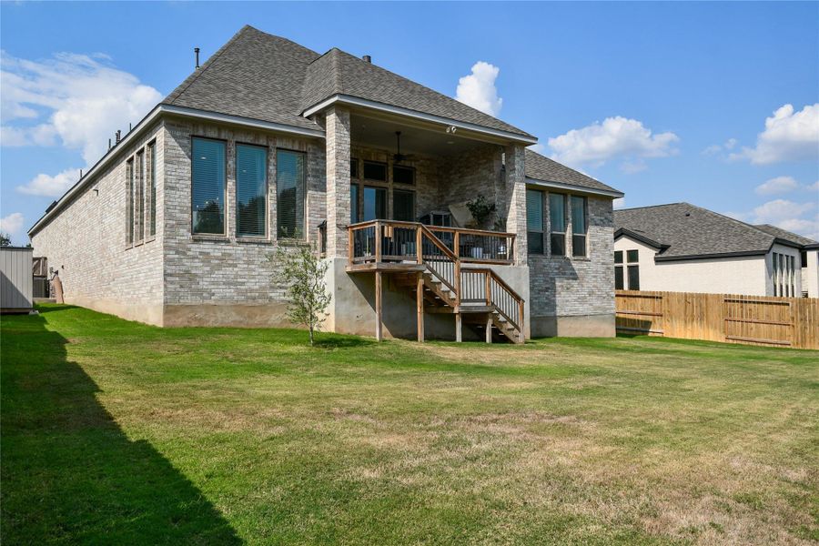 Rear view of house with brick siding, stairway, ceiling fan, and roof with shingles Rear view of house with brick siding, stairway, ceiling fan, and roof with shingles