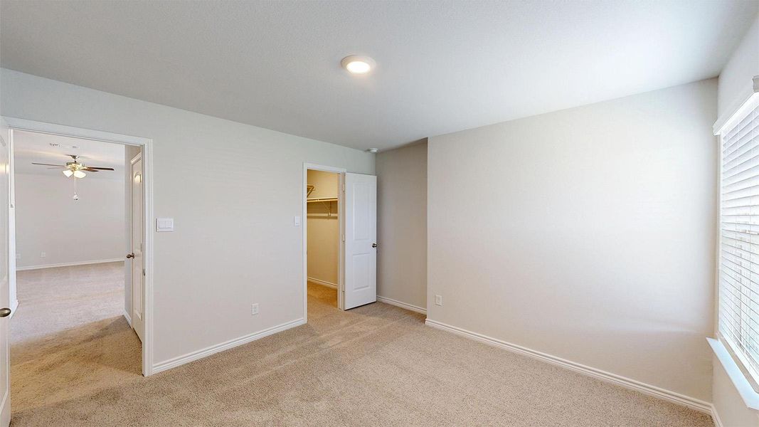 The room features light-colored carpeted floors and a window with blinds