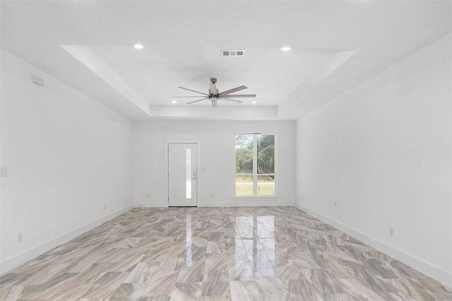 Unfurnished room featuring a tray ceiling and ceiling fan