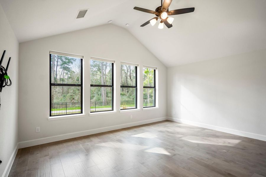 Spacious primary bedroom features large windows with scenic views and custom luxury blinds.
