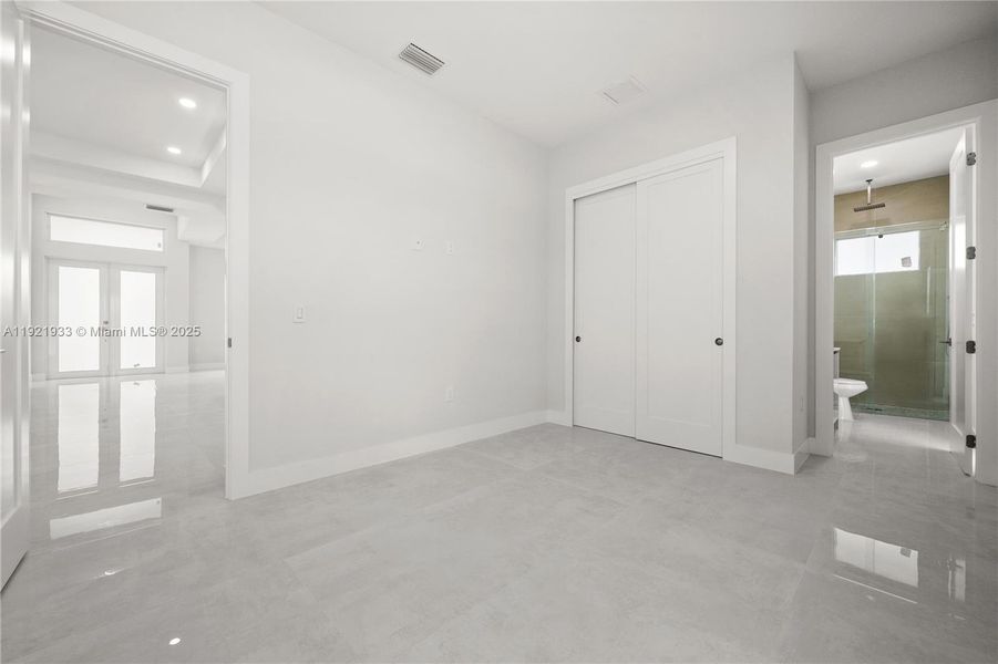 Unfurnished bedroom with french doors,recessed lighting, a closet, and connectedbathroom Unfurnished bedroom with french doors,recessed lighting, a closet, and connectedbathroom