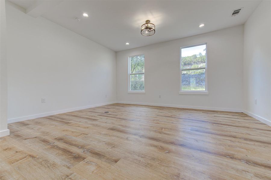 Empty room with light wood-type flooring and recessed lighting