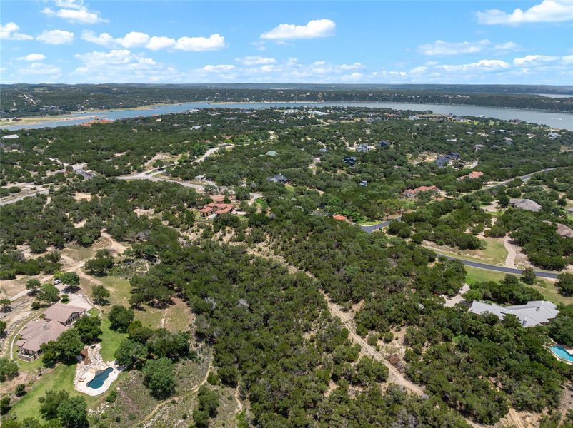 A sprawling landscape reveals a tranquil lake, surrounded by verdant trees and scattered residences. A sprawling landscape reveals a tranquil lake, surrounded by verdant trees and scattered residences.