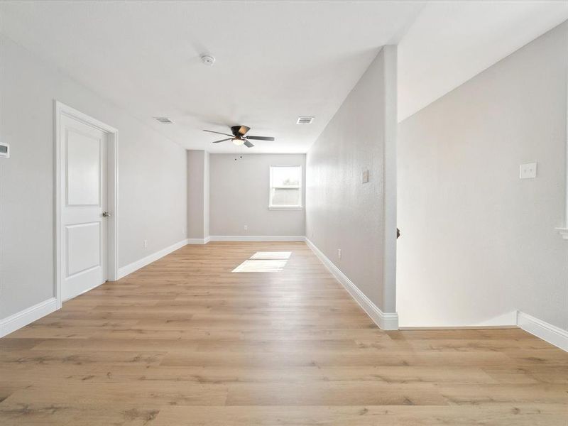 Unfurnished room with light hardwood / wood-style floors and ceiling fan