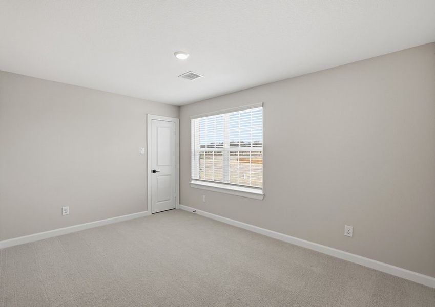 Secondary bedroom featuring a window and carpet flooring.