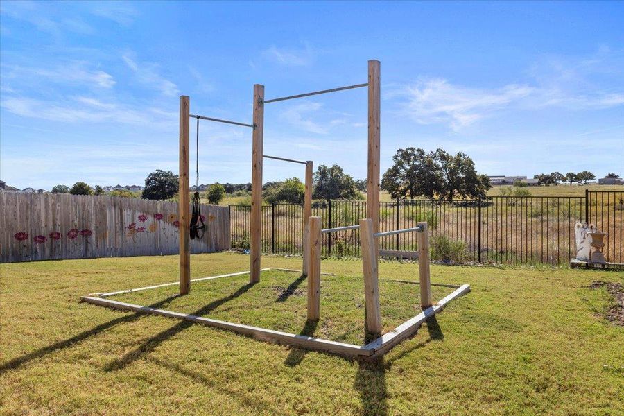 View of fenced backyard with personal outdoor gym conveys with property. View of fenced backyard with personal outdoor gym conveys with property.