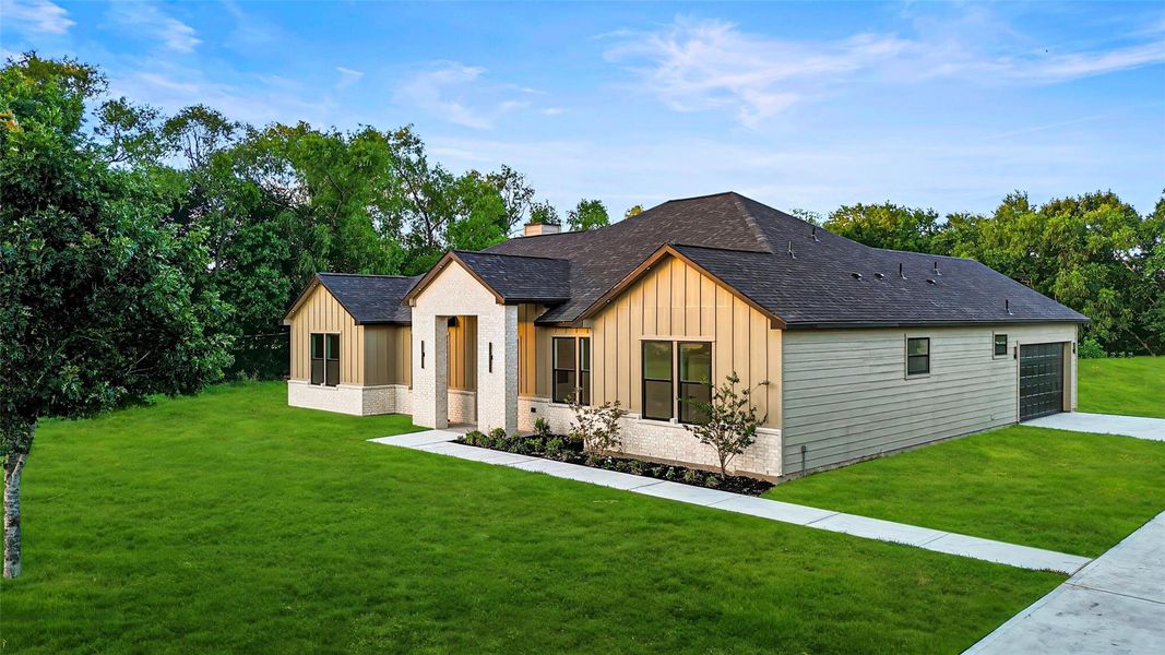 This photo showcases a modern, single-story home with a clean, stylish exterior. It features a combination of light and dark siding, and a paved driveway leading to a spacious garage. The home is surrounded by greenery, providing a serene and private setting. This photo showcases a modern, single-story home with a clean, stylish exterior. It features a combination of light and dark siding, and a paved driveway leading to a spacious garage. The home is surrounded by greenery, providing a serene and private setting.