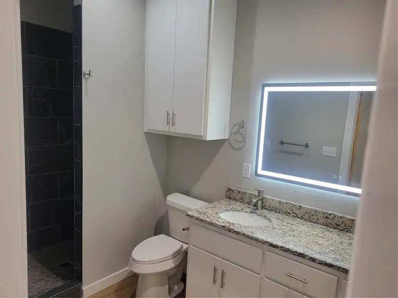 Vanity with light-toned granite countertop, undermount sink, and chrome faucet