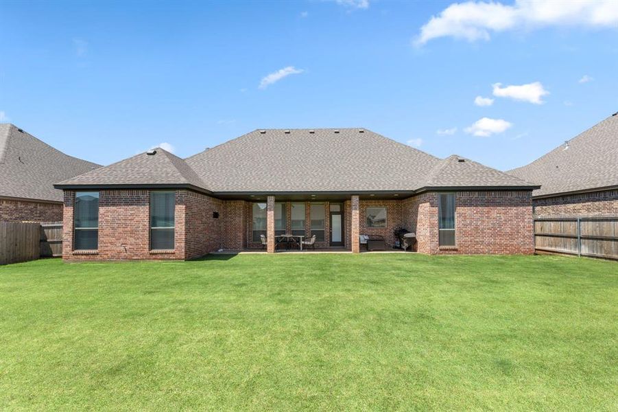 Back of house featuring a fenced backyard, a patio area, roof with shingles, and brick siding Back of house featuring a fenced backyard, a patio area, roof with shingles, and brick siding