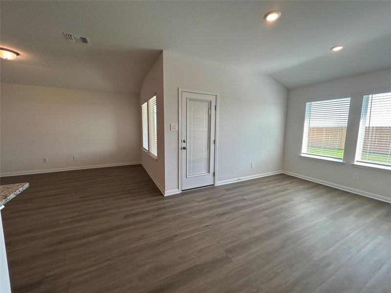 Unfurnished living room featuring dark wood-style flooring, recessed lighting, and lofted ceiling Unfurnished living room featuring dark wood-style flooring, recessed lighting, and lofted ceiling
