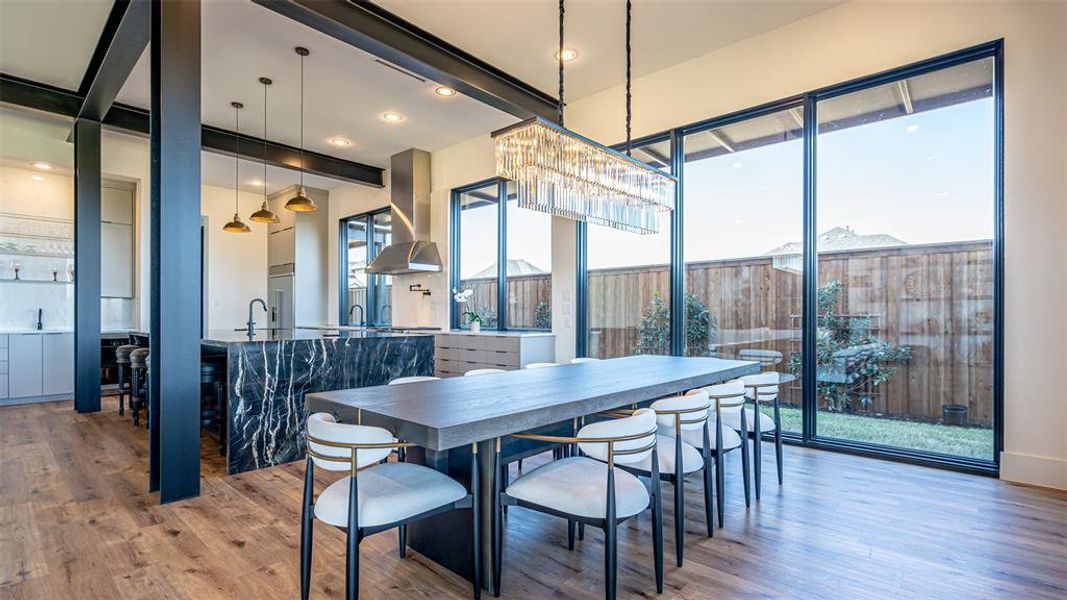 Dining area with beamed ceiling, hardwood / wood-style floors, and a notable chandelier