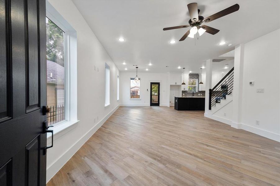 As you step inside, you'll discover a roomy living area with strategically placed recessed lighting and lovely picture windows to your left. The entire first floor is finished with tile flooring for a clean and modern look.