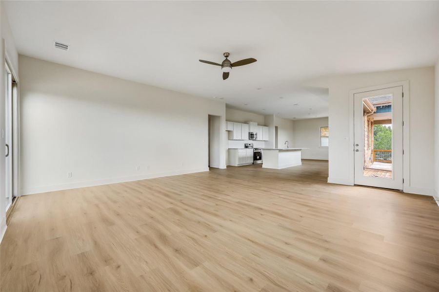 Unfurnished living room featuring a ceiling fan and light wood finished floors