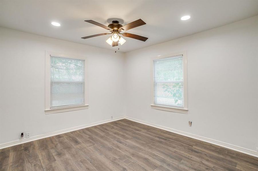 Spare room featuring dark wood-type flooring, plenty of natural light, recessed lighting, and ceiling fan