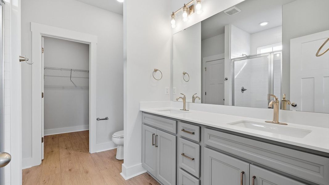 Sophisticated primary bathroom with expansive vanity and polished hardware at the Wells Crossing community
