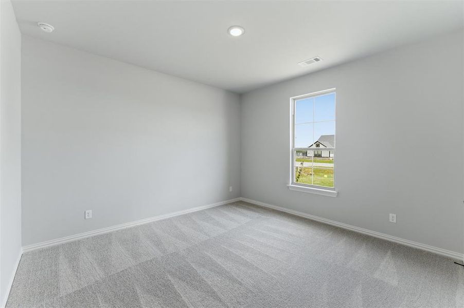 Spare room featuring light colored carpet and baseboards