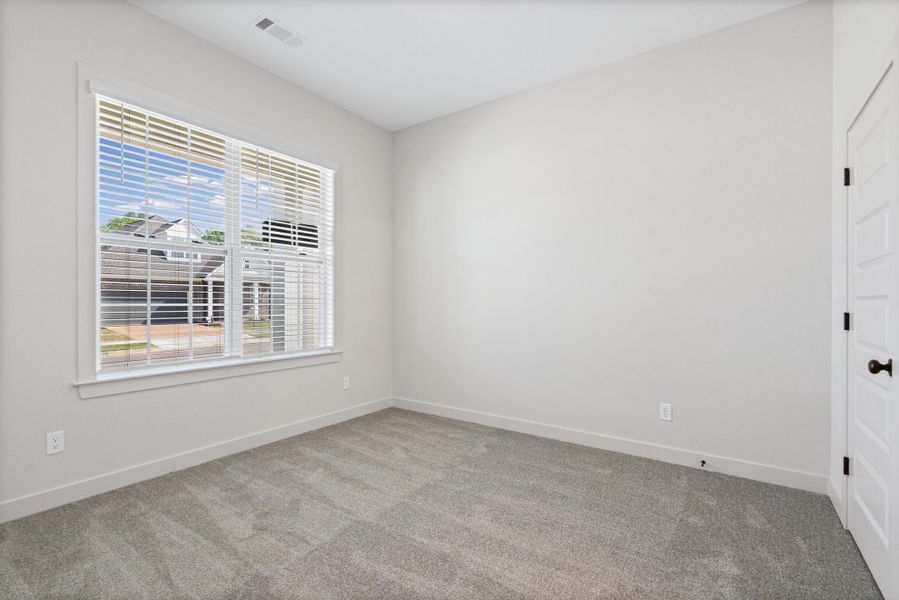 Unfurnished room featuring light carpet and baseboards