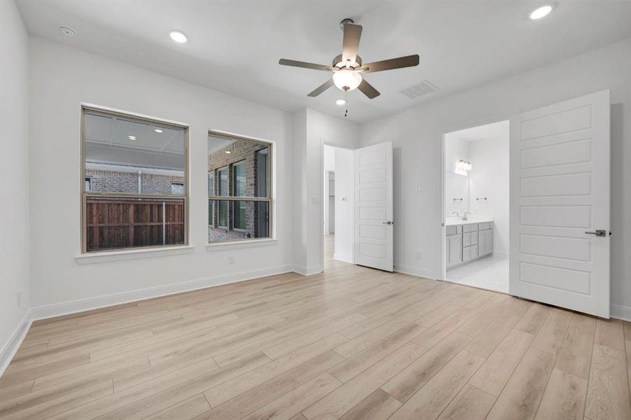 Unfurnished bedroom featuring a ceiling fan, recessed lighting, light wood finished floors, and ensuite bathroom Unfurnished bedroom featuring a ceiling fan, recessed lighting, light wood finished floors, and ensuite bathroom