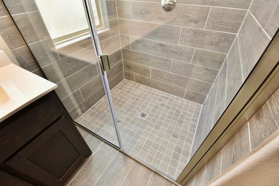 Bathroom featuring a shower stall, vanity, and wood finished floors Bathroom featuring a shower stall, vanity, and wood finished floors