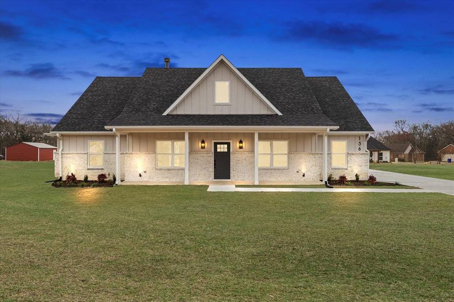 View of front of house with a yard and covered porch