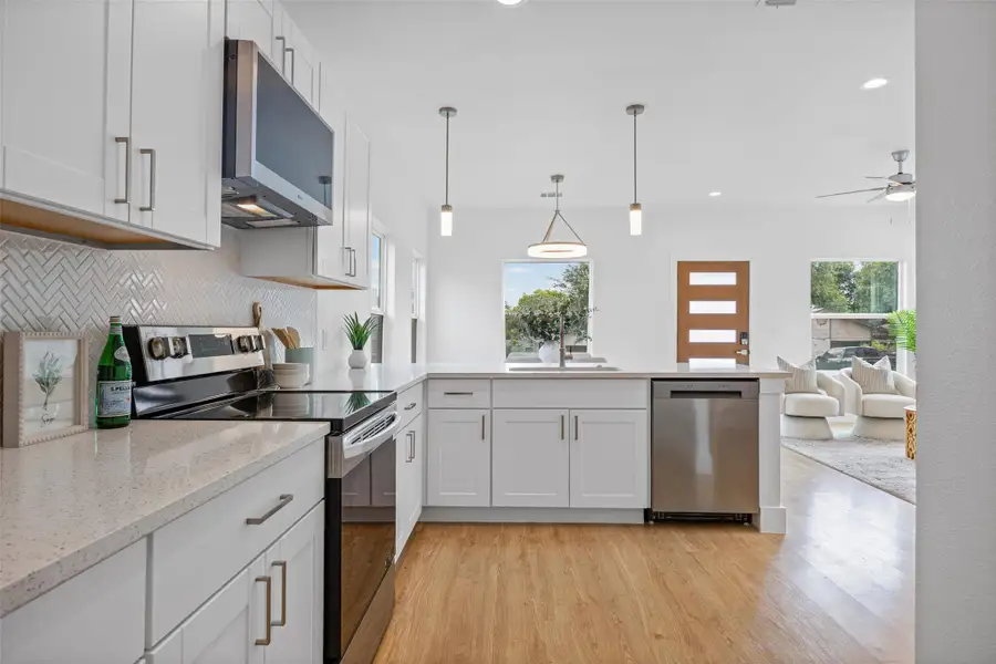 Bright, modern kitchen with light wood floors connects seamlessly to an inviting living area. Bright, modern kitchen with light wood floors connects seamlessly to an inviting living area.