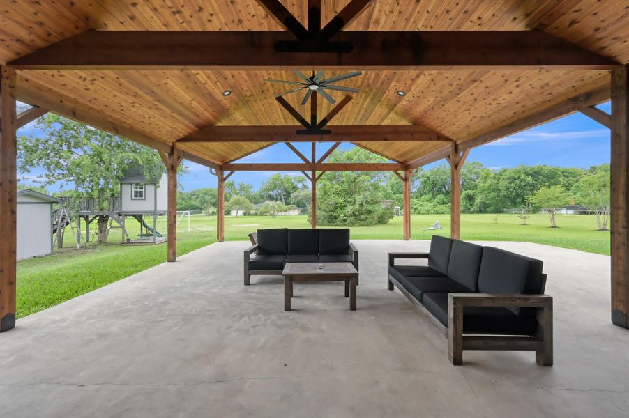 overlooks a large, lush backyard with a playhouse and open green space, perfect for relaxation and entertainment.