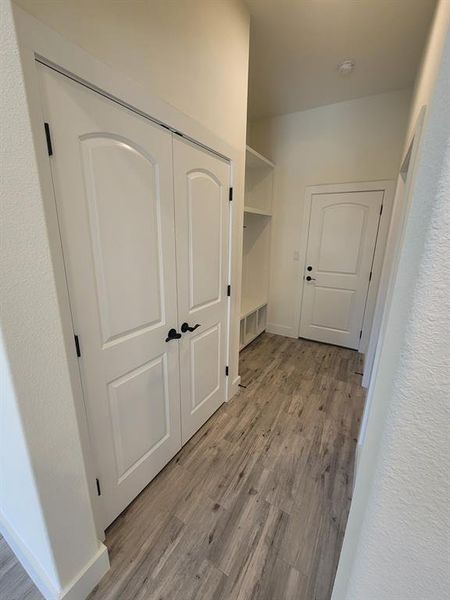 Hall with light wood finished floors and baseboards