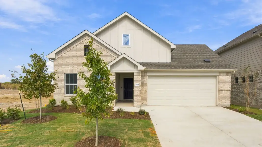 Front exterior of a new home in Carillon, Manor, TX, highlighting curb appeal (Image 22).