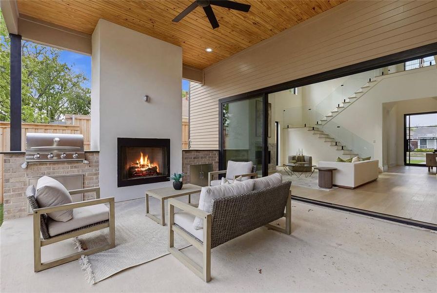 Covered outdoor patio featuring a built-in fireplace and integrated grill station Covered outdoor patio featuring a built-in fireplace and integrated grill station