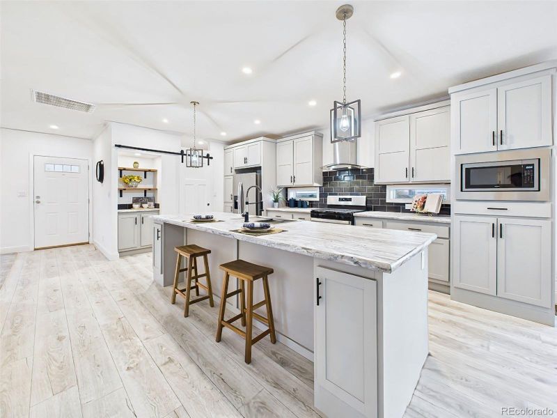 Expansive countertops with room for seating and meal prep, highlighted by modern cabinetry and finishes. Expansive countertops with room for seating and meal prep, highlighted by modern cabinetry and finishes.
