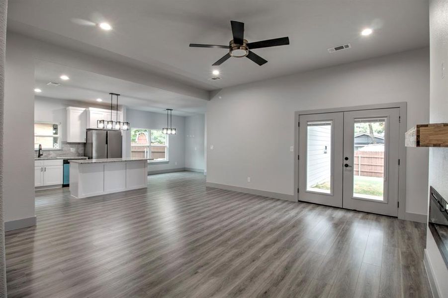 Unfurnished living room with recessed lighting, dark wood-type flooring, a ceiling fan, and french doors Unfurnished living room with recessed lighting, dark wood-type flooring, a ceiling fan, and french doors