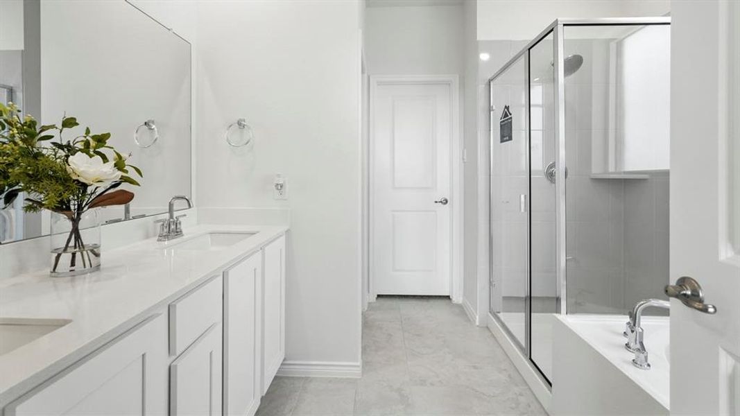 Bathroom featuring a dual vanity with white cabinetry and light-toned countertops, a glass-enclosed shower, a built-in tub with chrome fixtures, and a neutral tile floor